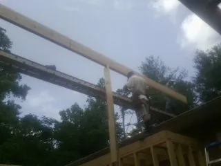Carpenter setting a ridge beam over a new addition frame — Ice Dam Removal by Roofing Brothers in Jonestown