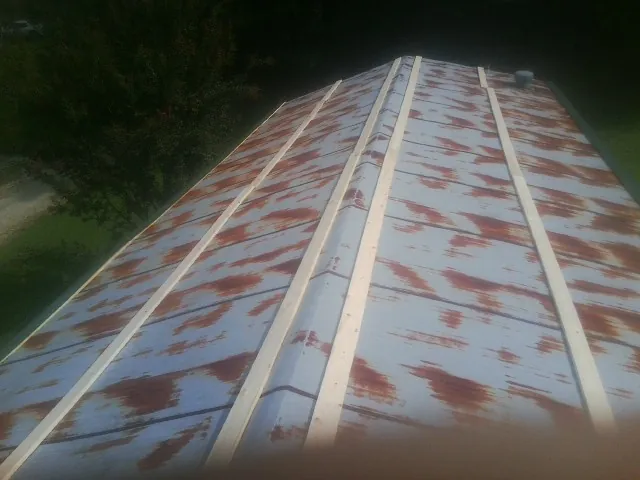 Rusted metal roof panels with new wood purlins before replacement — Storm Damage Roof Repair in Jonestown by Roofing Brothers