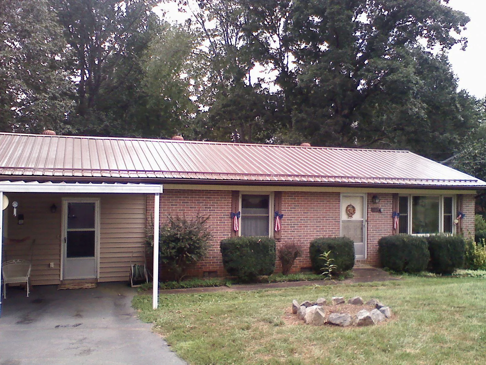 Bronze metal roof and carport on a brick ranch home — Roof Repair work by our crew in Jonestown