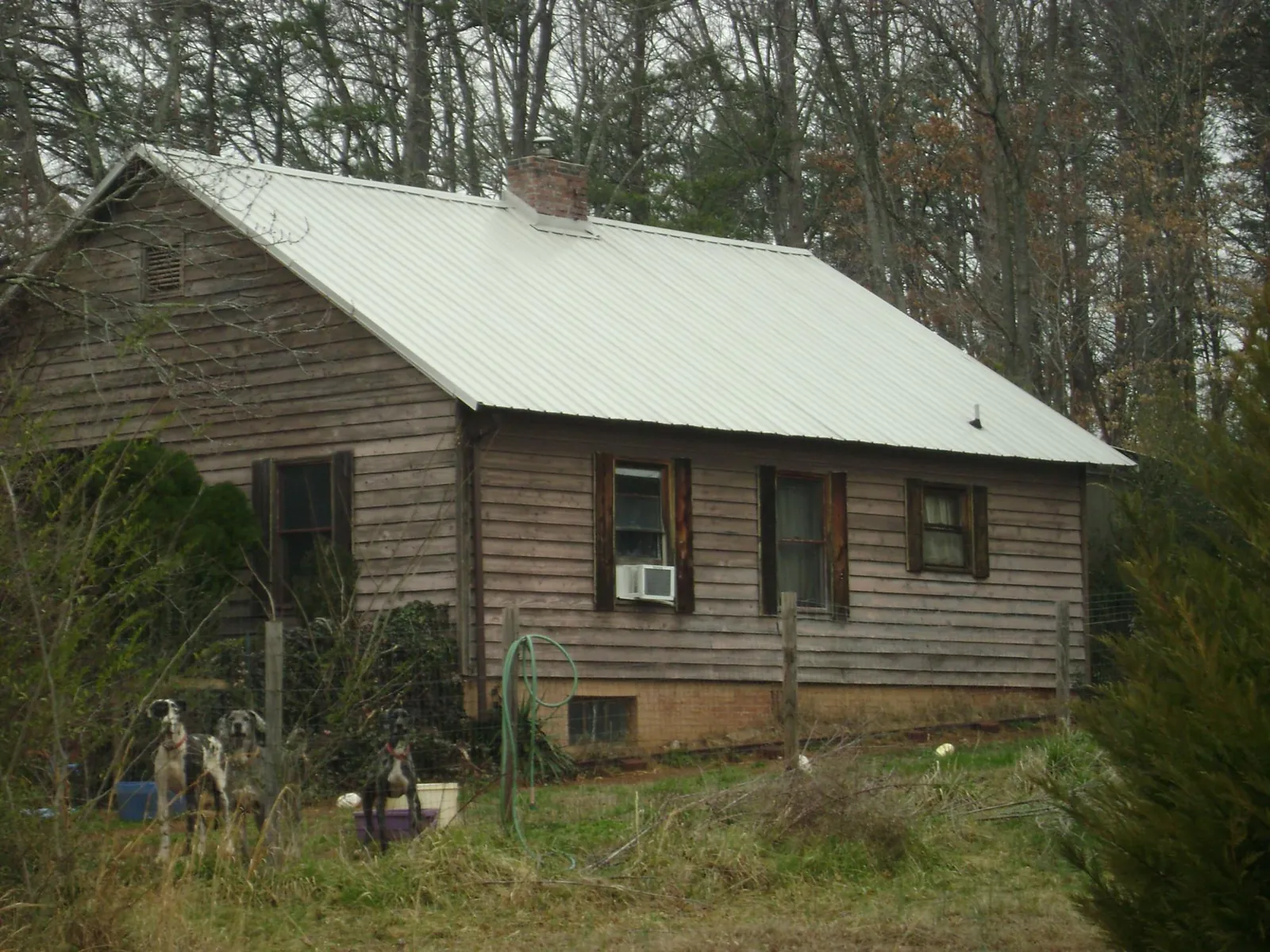 White metal roof on an old wood sided farmhouse, from a Metal Roof Installation job in Jonestown